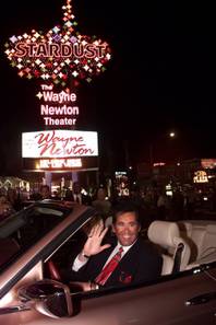 Entertainer Wayne Newton waves beneath the sign at the Stardust hotel-casino after turning on its switch in Las Vegas on Thursday, Jan. 20, 2000. The hotel was demolished in March 2007.