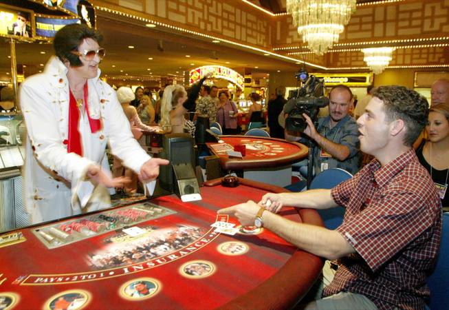 An Elvis Presley impersonating dealer flips a blackjack to Martin Paquin of Montreal, Quebec, during the unveiling of the Legends Pit at Imperial Palace in September 2003. The lineup of celebrity impersonating blackjack dealers, or dealertainers, includes Elvis, Liberace, Buddy Holly, The Blues Brothers, Madonna, Patsy Cline, Marilyn Monroe, Barbra Streisand, Rod Stewart, Elton John and Ray Charles.