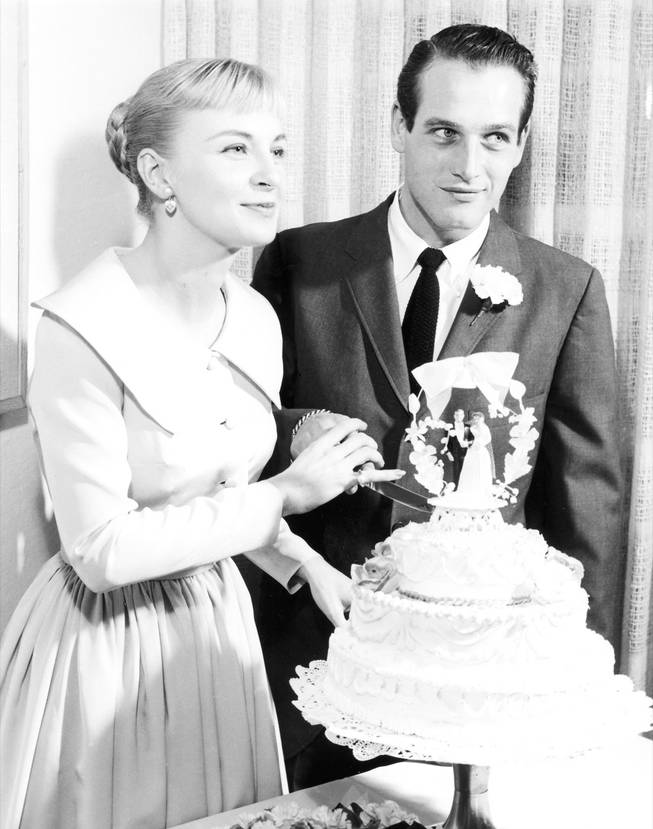 Actress Joanne Woodward and actor Paul Newman pose for cameras before cutting their wedding cake following the couple's Jan. 29, 1958 wedding at the El Rancho Vegas. They are still together today. 