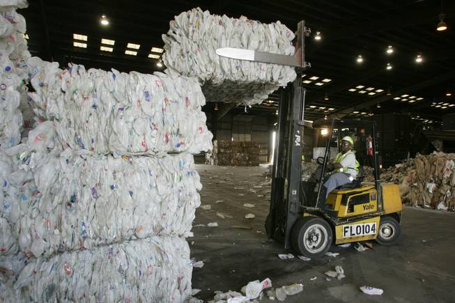 Forklift operator Godiell Harris arranges bales of high-density polyethylene plastic at the Republic Services recycling facility.