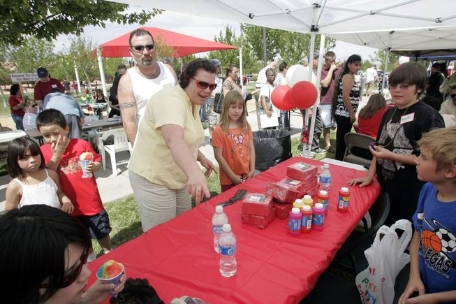 Anna Flanagan helps her neighbor Lexi Ramsay choose refreshments Saturday at the Save Our Community Ice Cream Social. Neighbors say they're glad their opposition to an apartment complex has given them an opportunity to get together and socialize.