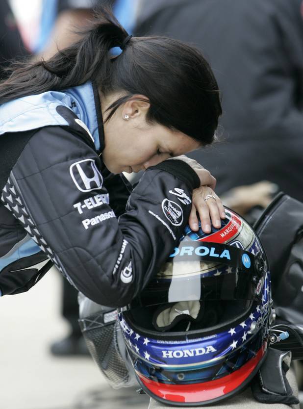 Race driver Danica Patrick rests her head on her helmet ...
