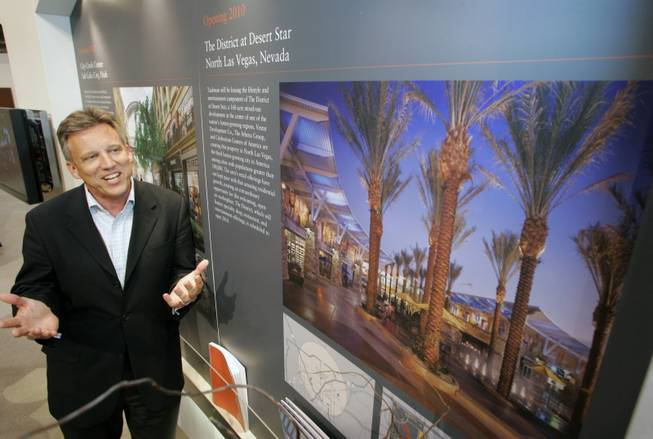 Steve Kieras, senior vice president of development for Taubman Centers, stands next to an illustration of The District at Desert Star, which is to be a mix of department stores and homes on 158 acres in North Las Vegas.