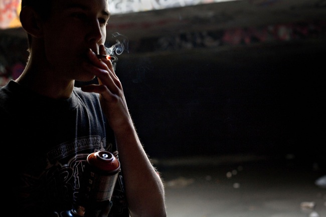 Ruckoh takes a drag on a cigarette while working on a mural.