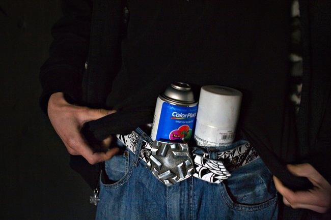 Stashing cans of paint, Ruckoh packs up to walk more than a half mile into a storm drain to paint a mural that will take more than six hours to finish.