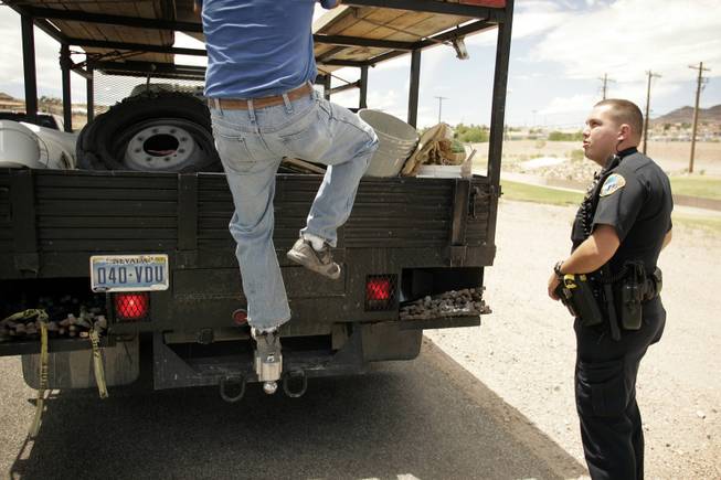 Boulder City Police Officer Chadd Richner talks to a man securing a load onto his truck while on patrol Sunday in Boulder City.