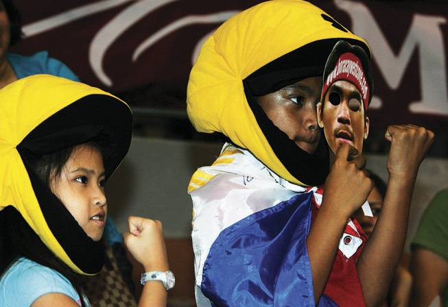 Alyana Pastor, left, 8, and Harley Elegino, 10, of Davao City, Philippines, don "Pacman" hats and make fists Friday in support of boxer Manny Pacquiao at the official weigh-in at the Mandalay Bay Events Center for his bout today with David Diaz of Chicago. Pacquiao, fighting as a lightweight for the first time, is a national hero in the Philippines.