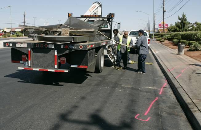 A clean-up crew loads the remains of a bus stop after a crash on Boulder Highway, just north of Flamingo Road, that killed one person who was waiting for a bus in July 2008. Another person who was at the bus stop and the driver of a sport utility vehicle were also hospitalized. 