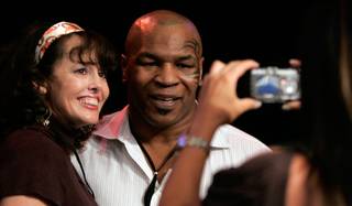 Mike Tyson poses for a photo with fan Michele Mosey before the Lynel Burton and Chris Finley welterweight boxing match at the Las Vegas Hilton. 