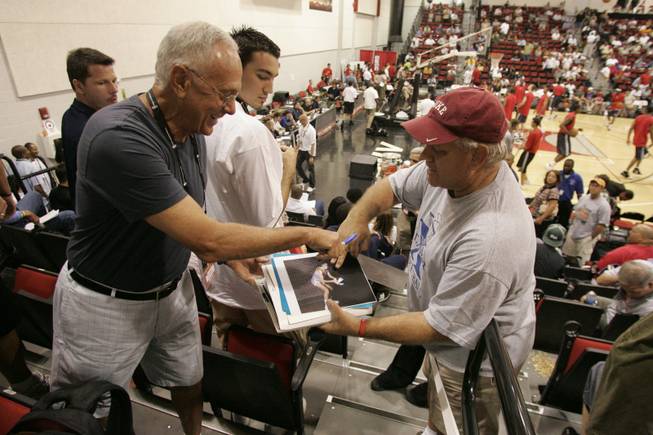 Charlotte Bobcats coach Larry Brown, left, signs vintage photos for Jerry Ankenbauer during Saturday's game.