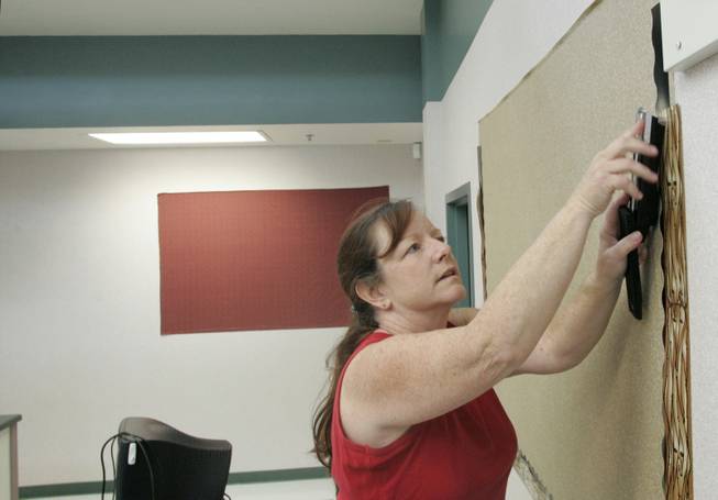 Karen Lundquist, a second grade teacher at the school, hangs decorations she purchased with her own money. Her principal has asked teachers to be sensitive to families when requesting supplies.  