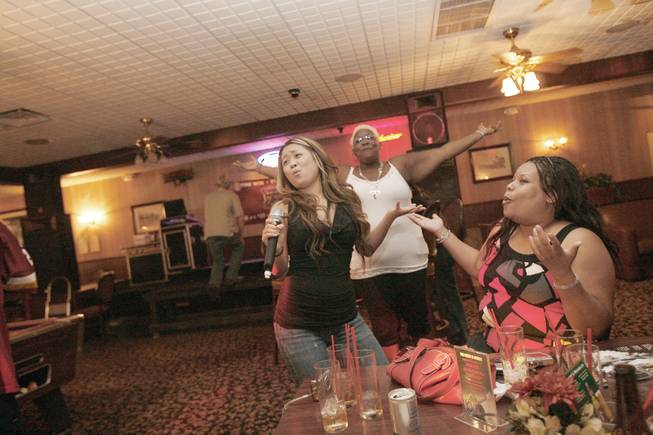 From left, friends Joyce Lyn, Yoli Hardyross and Keri Barber sing along to the theme song of the "Greatest American Hero" during Kamikaze Karaoke at JJ's Bar in Henderson.