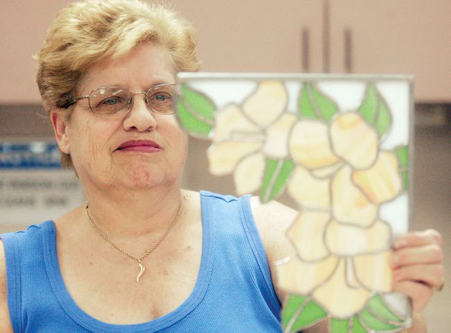 Anna Habel holds up her almost finished piece, a stained glass window decoration, at Mountain Shadows Community Center on July 21. Habel is a member of the stained glass club in Sun City Summerlin. 
