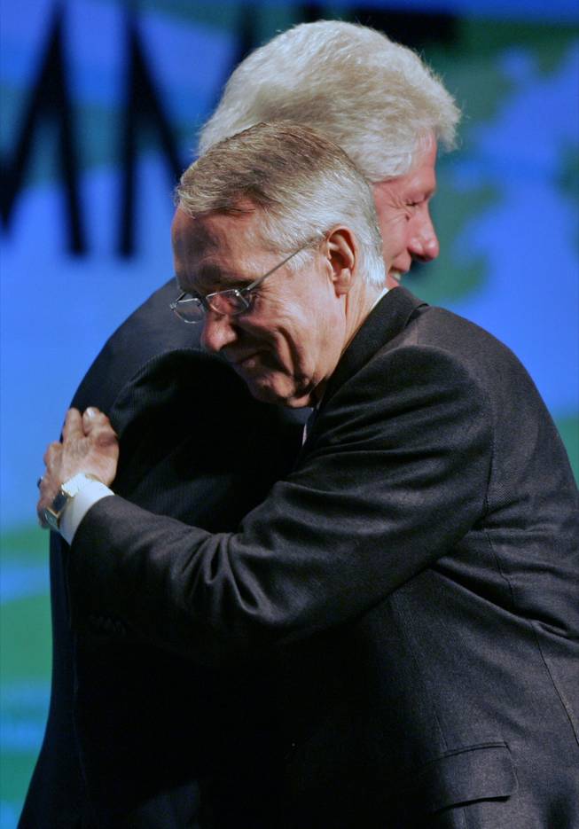 Senate Majority Leader Harry Reid, foreground, gives a hug to former President Bill Clinton during the opening session of the National Clean Energy Summit on Monday at the Cox Pavilion.