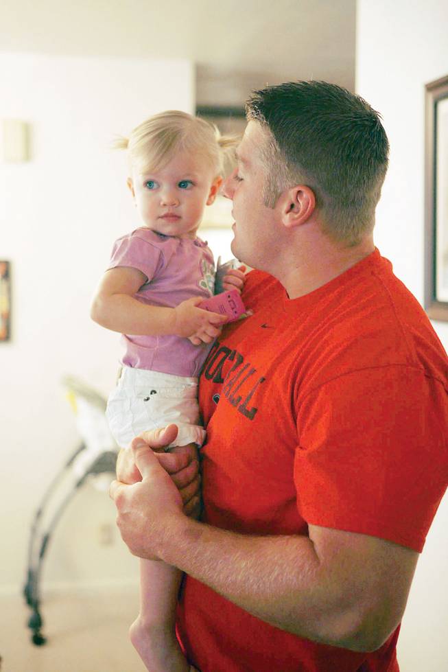 Ryan Worthen holds his daughter, Kaylee, at their Las Vegas home.