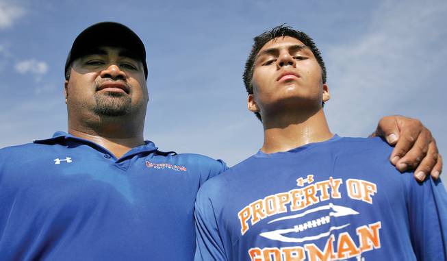 Bishop Gorman assistant football coach Lonnie Palelei, left, stands with son Evan, a junior linebacker for the Gaels. Lonnie Palelei, who played eight years in the NFL, has helped coach at Gorman since 2002.