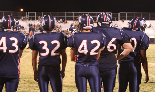 Members of the Coronado High School football team watch Friday as their teammates continue the assault against the squad from Clark High School.