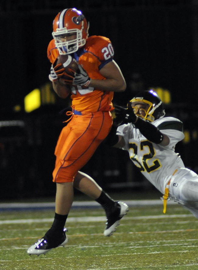Bishop Gorman safety No. 20 Evan Zeger leaps to intercept a pass intended for Service Cougars wide receiver No. 32 Neil Miyaoka during the first half of the Gaels' home opener on Friday.