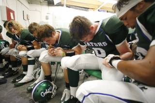 Members of the Green Valley High varsity football team listen to some words from head coach Matt Gerber, not shown, before a home game against Bonanza on Friday night. 