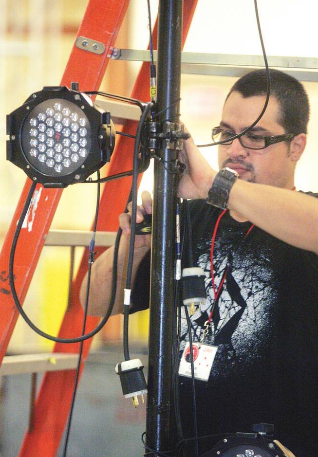 Che Alvarado sets up lights for the Jerry Lewis MDA Telethon, which will be broadcast from South Point on Sunday.
