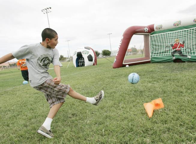 Jose Arvizu, 12, kicks a soccer ball at an inflatable soccer goal during the 2008 Kohl's US Youth Soccer American Cup, an interactive village for kids to play and learn soccer held at the Brinley Community School Saturday, August 30, 2008.