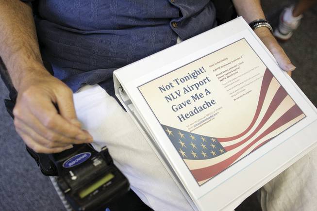 Founder Ed Gobel holds a binder with his group's name on the cover. He helped organize the meeting to give residents a chance to air their safety concerns after two small planes crashed last month into houses near the North Las Vegas Airport.