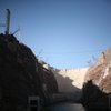 Towers are visible on either side of the Hoover Dam as construction on a bypass bridge continued last year. Boulder City officials want to build a bypass toll road to the dam.
