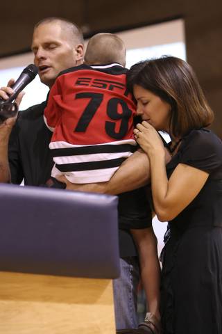 Overcome with sadness, Drew Stevens embraces his youngest son, Sammy, while standing beside his wife, Barbara, and thanks students and friends attending a vigil for his son, Josh, who died after being thrown from a golf cart Friday. Twelve-year-old Josh Stevens was a seventh-grader at the school.