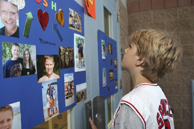 Spencer Cofer looks at photographs of his friend, Josh Stevens, who died in September 2008 after being thrown from a golf cart. A vigil was held at Bob Miller Middle School in Stevens' honor.
