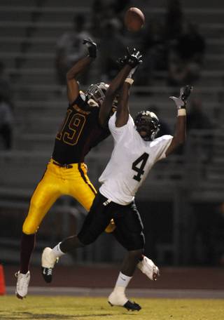 Dragons wide receiver Chris Jones (19) leaps for a long pass while being covered by Palo Verde defensive back Sidney Hodge (4) late in the first half of a game at Del Sol High School on Friday. Hodge intercepted the ball on the play.