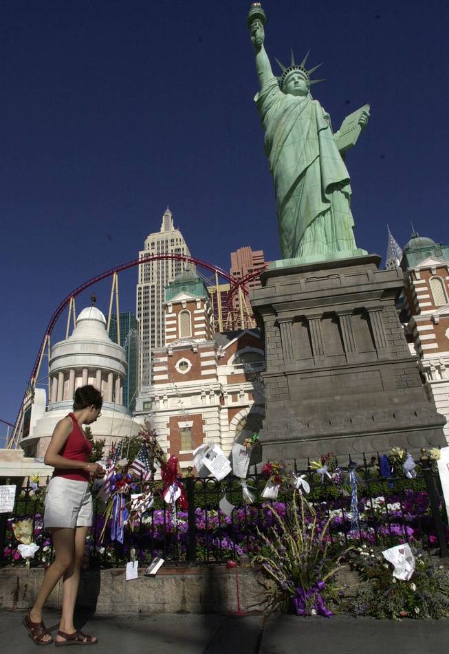 Norma Isiordia, from Los Angeles, stops to read messages left at an impromptu memorial for terrorism victims at the fence at the New York New York Hotel Casino Tuesday on Sept. 18, 2001.