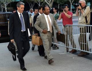 O.J. Simpson arrives Monday for the first day of his trial at the Clark County Regional Justice Center. Attorney Gabriel Grasso is at left. 