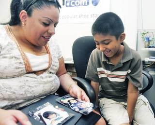 Tanya Sotelo looks at photos with her son, Angel, during a bone marrow drive at Zappos Headquarters on Friday.  Angel, 6, was diagnosed with Fanconi anemia when he was 3.