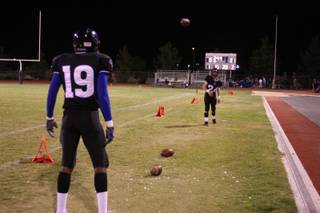 Desert Pines' Paul Bennett (19) warms up with Jonathon Tagle (24) during the second quarter. Desert Pines lost 21-0 to Las Vegas Friday night.