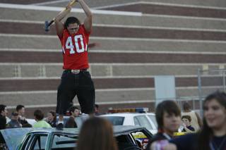 At the tailgate party before Coronado High School's homecoming game against rival Green Valley, senior Steve Salgado hits a car painted with anti-Gator slogans with a sledgehammer.