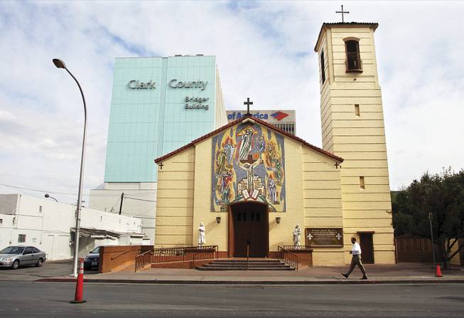 Saint Joan of Arc Roman Catholic Church on Casino Center Boulevard in downtown Las Vegas is dwarfed by commercial buildings.