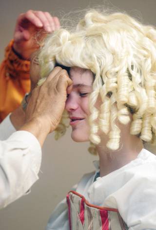 Somewhat to his embarrassment, a wig is placed on Cameron Osborn's head as he is dressed as Queen Elizabeth during a visit by performers from Shakespeare in the Park at Hank and Barbara Greenspun Junior High School Sept. 29.  One of the first things the students learned from the thespians was that only men were allowed to act during Shakespeare's time, so they performed both male and female roles.  