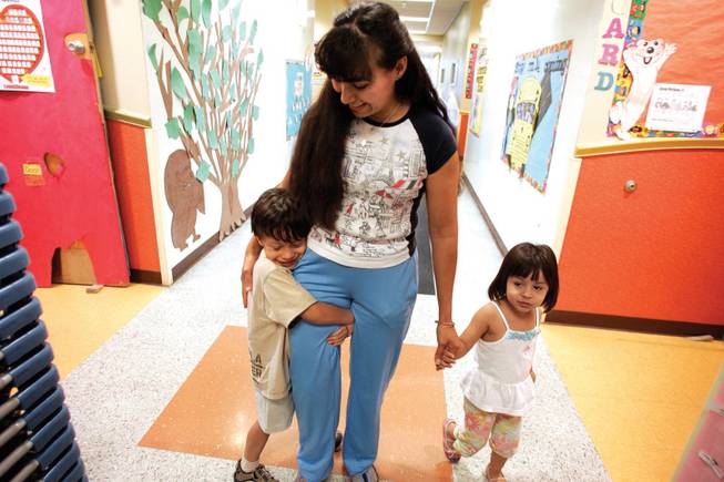 Annie Pena gets a hug from her son Josued, 4, after picking up him and her daughter Haddasah, 2, from a Head Start program last month. The full-day child care the program provides allowed Pena to take a part-time job when her husband's earnings fell along with the economy.