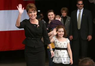 Republican vice presidential nominee Alaska Governor Sarah Palin, left, arrives for a rally with daughters Piper, right, 7, and Willow, center, 13, and son Trig (held by Willow) in Henderson, Nev. Oct. 21, 2008. 