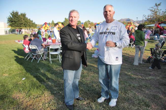 Senior Pastors Chris Bennett, left, leader of New Community Church, and Rob Boyd of Green Valley Baptist Church join hands at the churches' annual steak fry and picnic at Silver Springs Park.