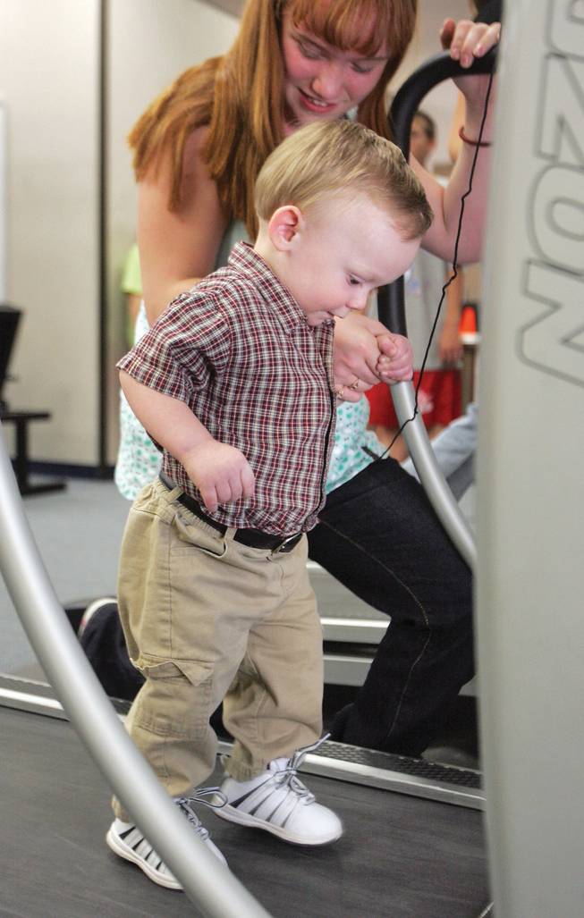 Tiffany Nelson, eighth grade, helps her brother, Justin Newcomer, 19 months old, walk on a treadmill during Thurman White Middle School's family fitness and dinner night on Oct. 16.