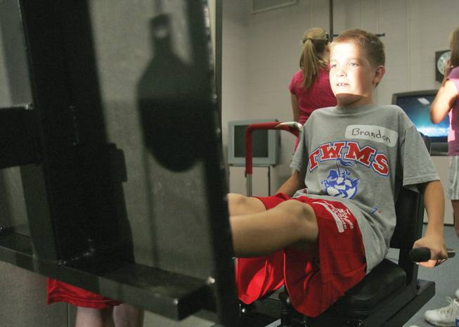 Brandon Belanger, a seventh-grader, works out his legs during Thurman Middle School's family fitness and dinner night on Oct. 16.