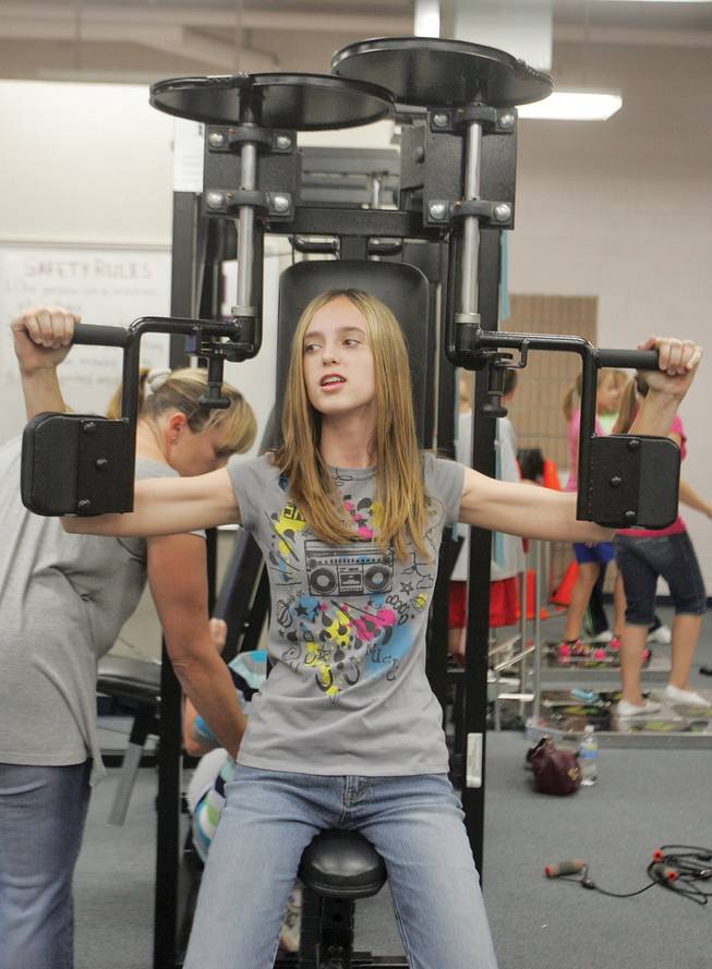 Courtney Sheets, eighth grade, exercises her arms during Thurman Middle School's family fitness and dinner night on Oct. 16.