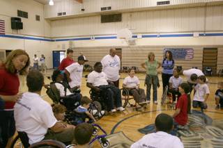 A volunteer at the Paralympics Academy gathers students for introductions. The academy meets one day a month after school.
