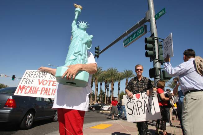 McCain-Palin supporter Jody Black, left, stands on the corner of Green Valley and Paseo Verde parkways as Ashley Hall, right, brings up a sign outside the Henderson Pavilion where Republican vice presidential candidate Sarah Palin will be speaking Tuesday, Oct. 21, 2008. Black said she planned to bring "Miss Liberty" inside the rally but when was told she probably couldn't, she took up a spot on the corner. 