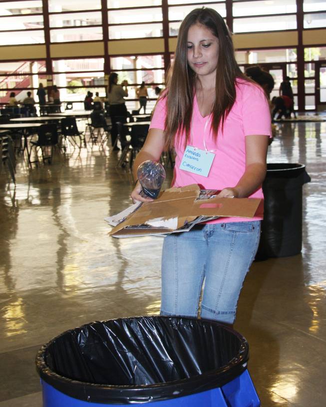 Amanda Escalera sorts out recyclable material from a trash can and takes them to the proper recycling bins during a recycle event at Cimarron-Memorial High School.
