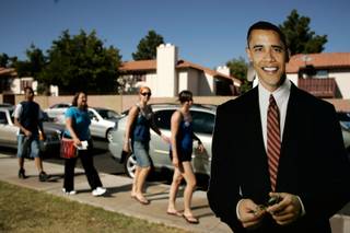 Supporters walk by a cardboard cutout of Sen. Barack Obama before a rally with the Democratic presidential candidate at Bonanza High School on Saturday.