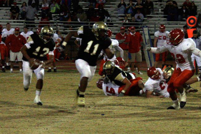 Cheyenne's Kaeo Helekahi (12) runs the ball while Ronnie Green (11) blocks for him.