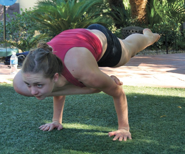 Laura Proud, 18, who has practiced bikram yoga for five years, warms up with a few asanas for the yoga championships at the annual Bishnu Ghosh Yoga competition at Town Square Park on Sunday.