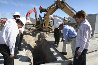 Sue Enge of Pulte Homes, right, and top-level managers of TWC Construction inspect the first excavated hole, which exposed existing underground pipes at the construction site of the Sun City Anthem recreational center on Friday.
